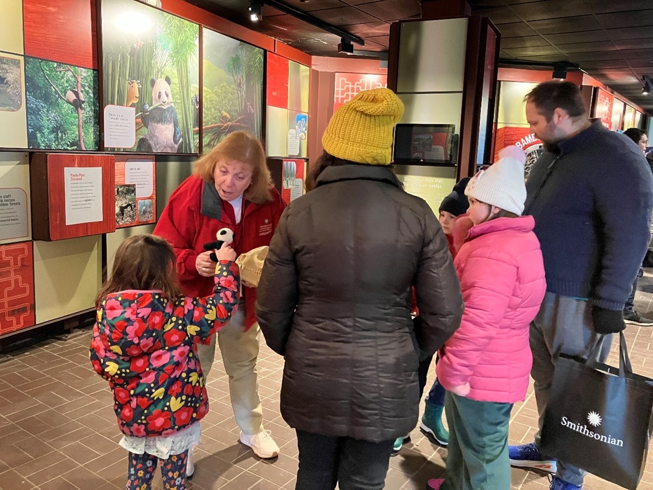 A volunteer engaging with zoo visitors.